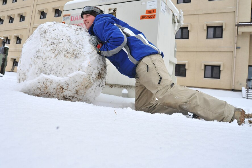 Senior Airman Jacob Chance, 8th Security Forces Squadron operations center controller, builds a snowman in front of his dormitory at Kunsan Air Base, Republic of Korea, Jan. 4, 2012. The Wolf Pack enjoyed their first snow day of the new year. (U.S. Air Force photo by Senior Airman Brittany Y. Auld/Released)