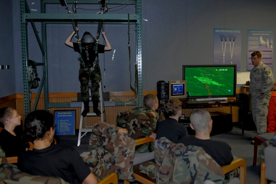 U.S. Air Force Staff Sgt. Robert Colliton, 18th Operations Support Squadron survival, evasion, resistance and escape specialist, gives each Civil Air Patrol cadet a chance to use the parachute simulator at Kadena Air Base, Japan, Dec. 29, 2011. The simulator was merely one of the military opportunities the cadets were given a look into during the week-long 2011 Okinawa Squadron Civil Air Patrol Encampment. (U.S. Air Force photo by Airman 1st Class Tara A. Williamson/Released)