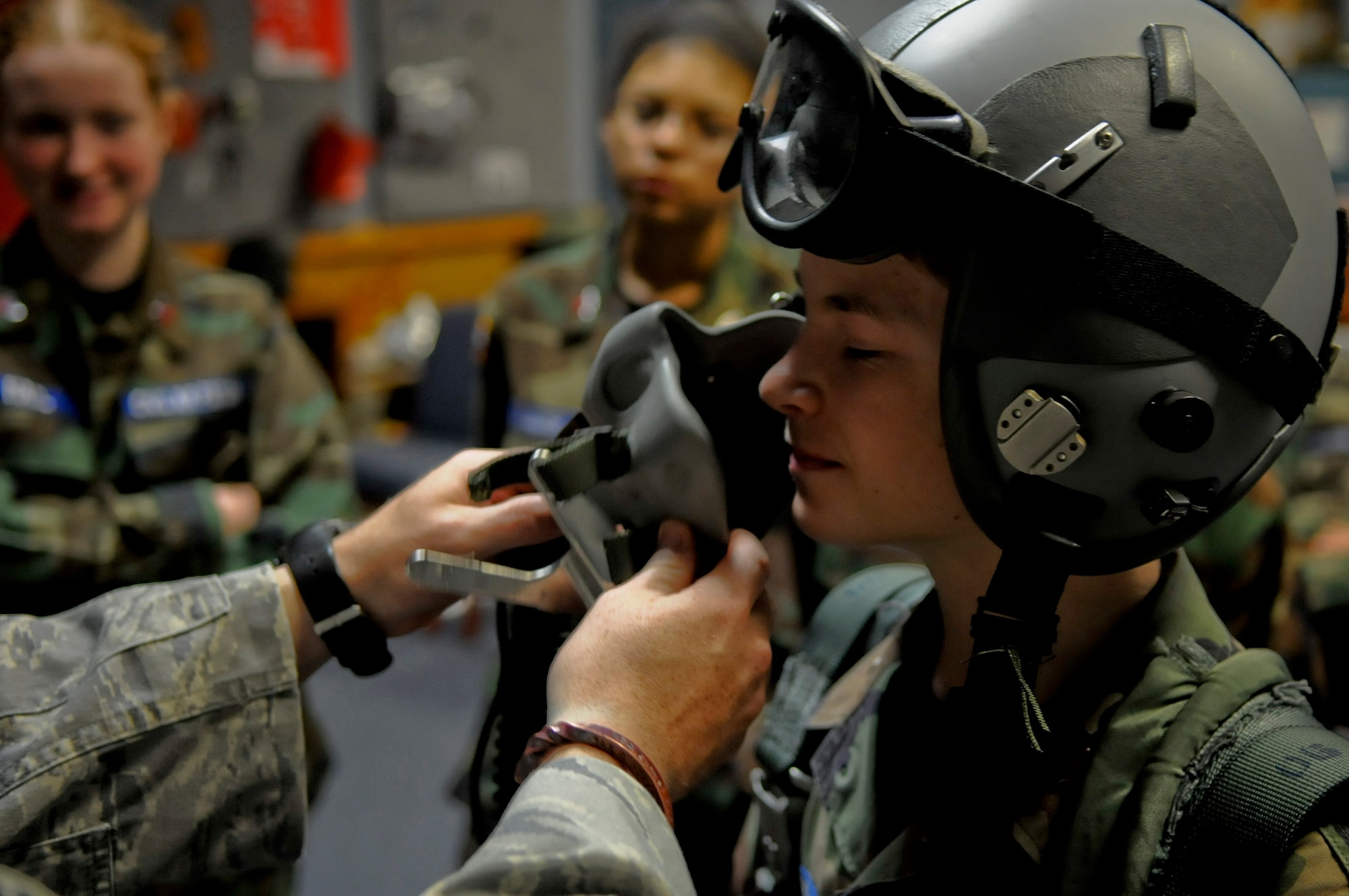 U.S. Air Force Staff Sgt. Robert Colliton, 18th Operations Support Squadron survival, evasion, resistance and escape specialist helps cadets in the Civil Air Patrol try on parachute equipment during the week-long 2011 Okinawa Squadron Civil Air Patrol Encampment at Kadena Air Base, Japan, Dec. 29, 2011. This annual event gave cadets a chance to live a military style life for the week. (U.S. Air Force photo by Airman 1st Class Tara A. Williamson/Released)