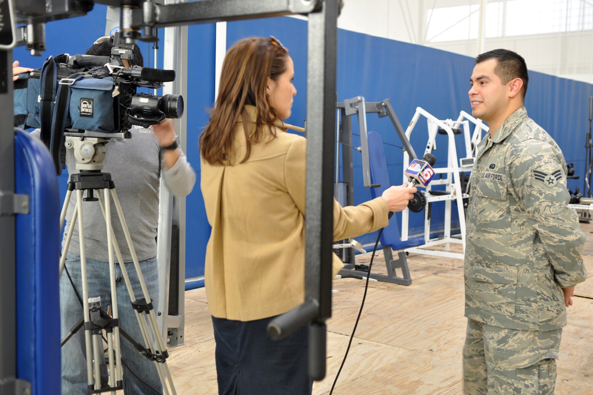 Senior Airman Michael Vargas, a fitness specialist assigned to the 2nd Force Support Squadron, explains the benefits of a good physical fitness plan to Leslie Draffin, who is a reporter for KTAL Channel 6 in Shreveport, La., at the Fitness Center on Barksdale Air Force Base, La., Jan. 4, 2012. Draffin was at Barksdale with her cameraman Chang Howang to report on people’s New Year’s Resolutions to become more fit during 2012, as well as the remodeling progress of the Fitness Center. A Re-Grand opening is scheduled for Jan. 9, 2012. (U.S. Air Force photo by Master Sgt. Jeff Walston/Released)