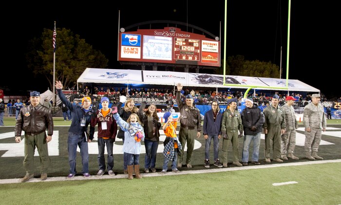 Nellis Air Force Base Airmen and their families wave to the crowd at the MAACO Bowl game Dec. 22, 2011, at Sam Boyd Stadium in Las Vegas, Nev. From right, the military representatives recognized included Maj. Gen. James Hyatt, U.S. Air Force Warfare Center commander; Capt. Charles Hansen of the 820th Red Horse Squadron; Maj. Jeff Personius of the 422nd Test and Evaluation Squadron; Lt. Col. Murray Nance of the USAFWC; Lt. Col. Jason Forest of the 706th Fighter Squadron and Col. William Tracy of the USAFWC. (Courtesy photo)