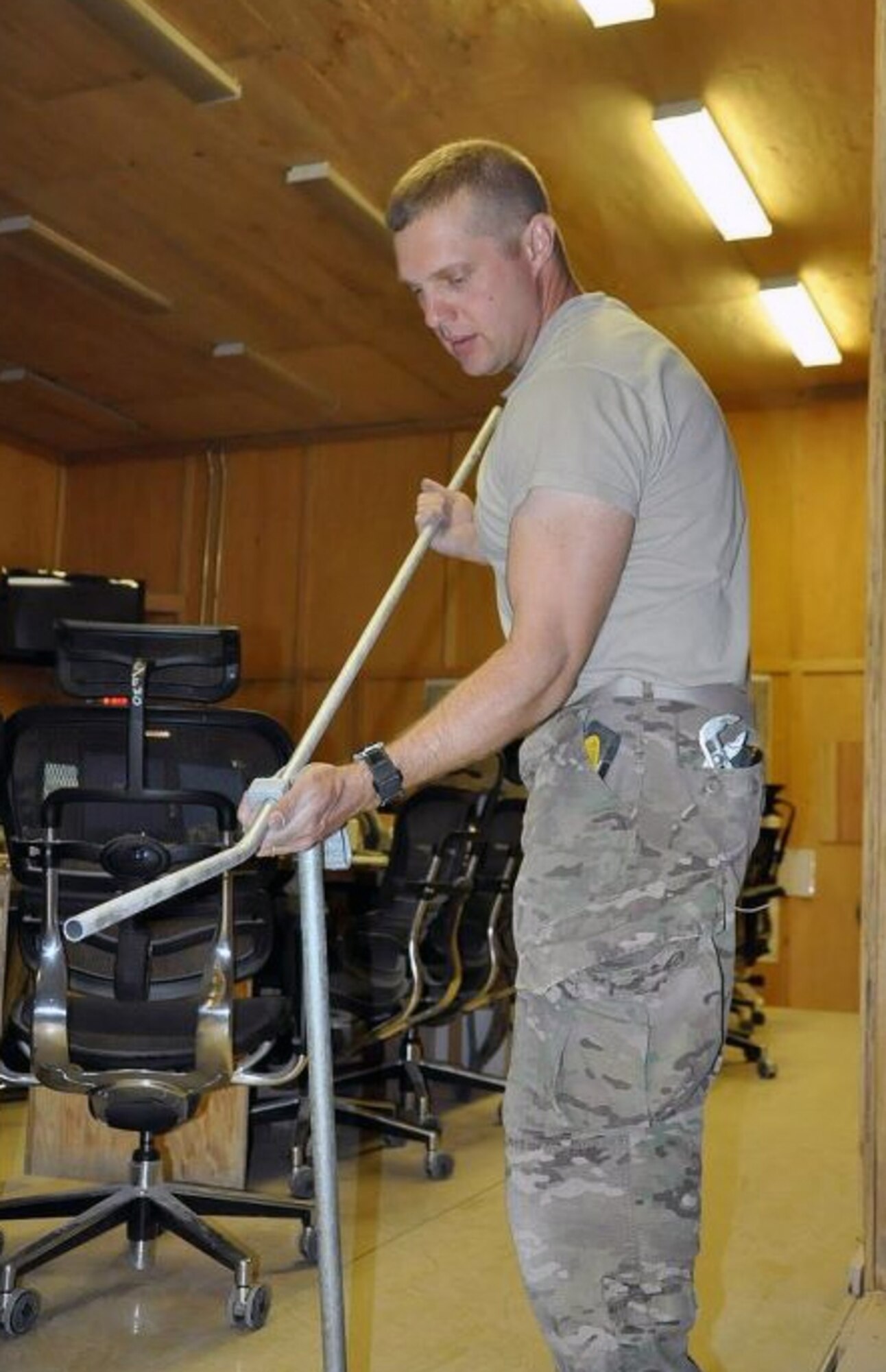 Air Force Master Sgt. Michael Caume, a resident of Blue Springs, Mo., uses a pipe bender to bend conduit prior to re-routing electrical wires for overhead lighting in the remodel at the back of the 3rd Brigade Combat Team, 1st Armored Division Joint Operations Center. A member of the International Brotherhood of Electrical Workers, Caume brings little tips and tricks to get jobs done fast and efficiently. (U.S. Army photo/Sgt. John D. Ortiz)
