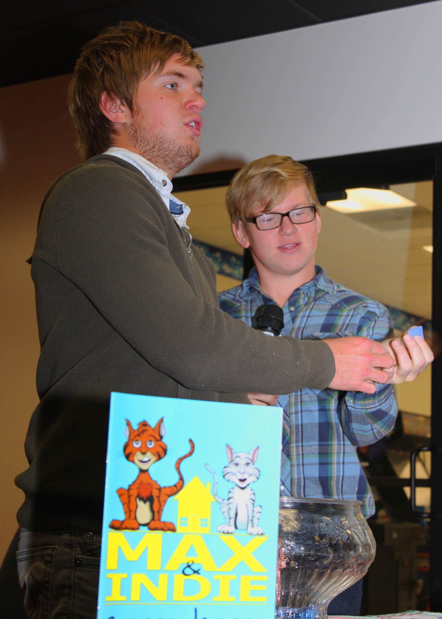 The Brochu brothers call out raffle numbers for limited quantities of Max and Indie Come Home, during an Edwards Children's Library event here Dec. 16. (U.S. Air Force Photo by Meredith Mingledorff) 