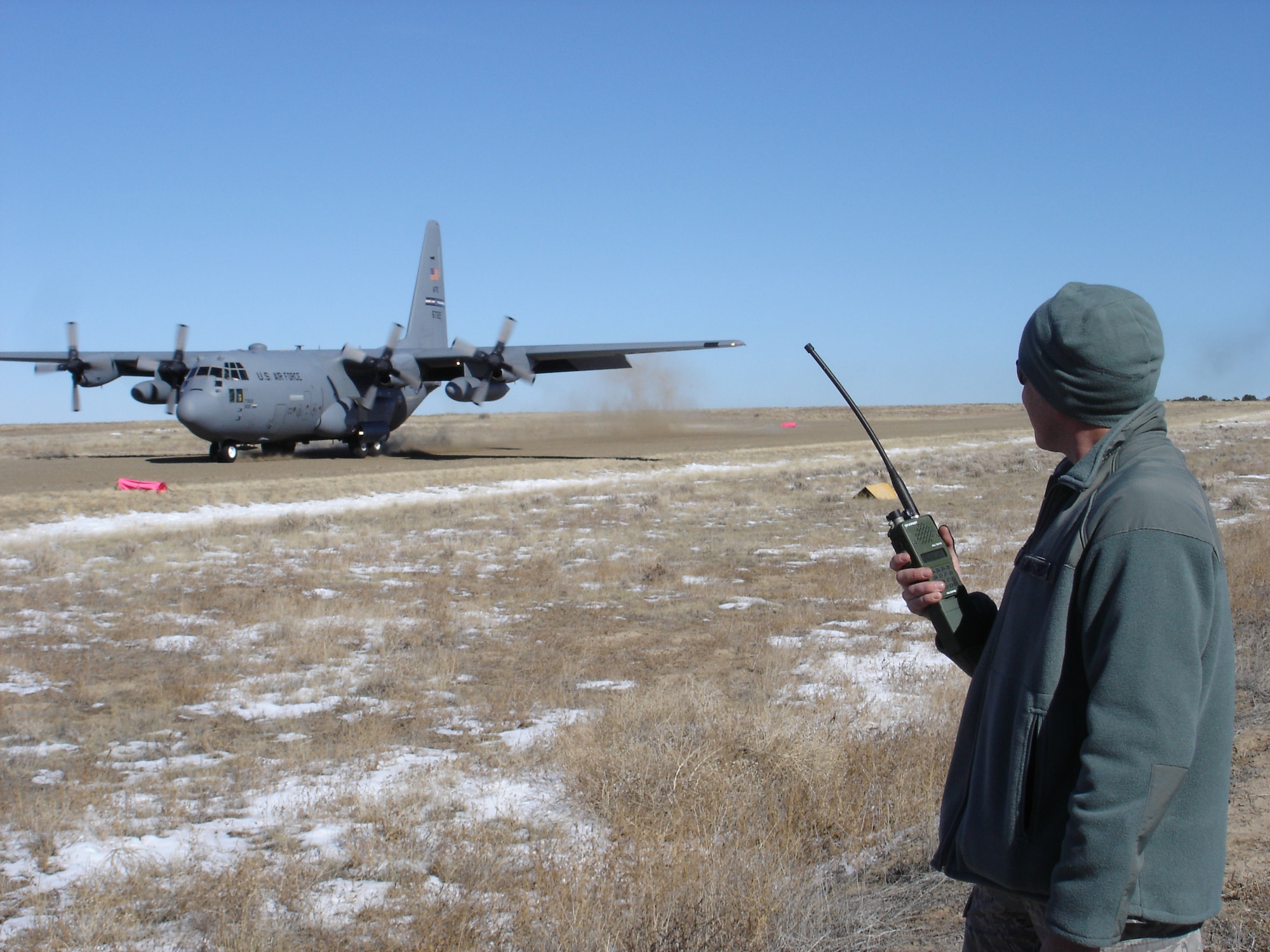 Capt. Mike Modesto, 621st Contingency Response Wing landing zone safety officer, watches a C-130 Hercules land at Pinon Landing Zone, Colo. during a training exercise Nov. 3, 2011. Modesto was part of a small group of CRW officers being certified to select, inspect and mark landing zones for day and night operations in remote terrain away from established airfields. These skills will increase the number of areas where CRW forces can operate safely.  (U.S. Air Force photo by Capt. Mike Modesto) (Released)