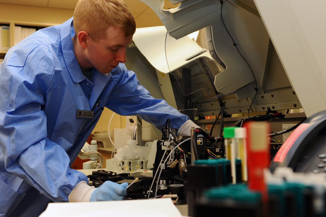 Airman 1st Class Joseph Deboes, 28th Medical Support Squadron medical laboratory technician, cleans and prepares a chemistry analyzer for tests on Ellsworth Air Force Base, S.D., Dec. 27, 2011. Blood and body fluids are analyzed to assist doctors in diagnosis. (U.S. Air Force photo by Airman 1st Class Zachary Hada/Released)