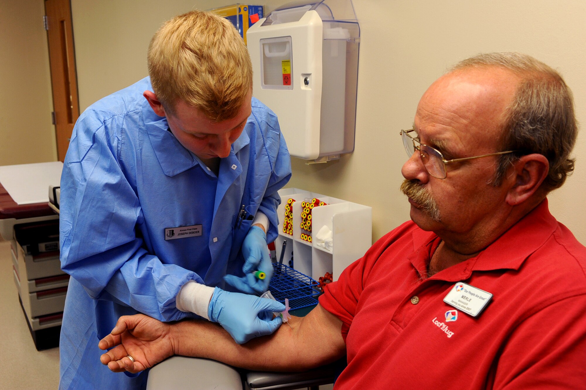 Airman 1st Class Joseph Deboes, 28th Medical Support Squadron medical laboratory technician, draws blood from Merle Sackett on Ellsworth Air Force Base, S.D., Dec. 27, 2011. Blood is drawn for various tests to diagnose any problems or impurities. (U.S. Air Force photo by Airman 1st Class Zachary Hada/Released)
