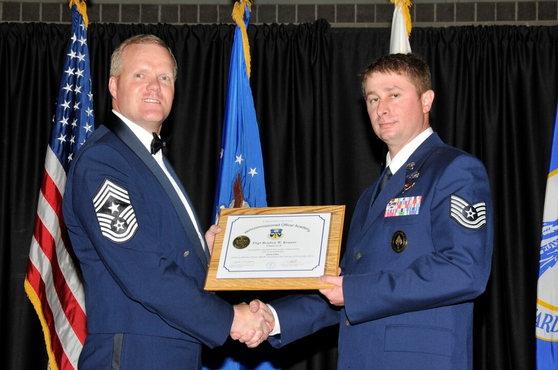 McGHEE TYSON AIR NATIONAL GUARD BASE, Tenn. -- Tech. Sgt. Reuben W. Krause, right, receives the distinguished graduate award for NCO Academy Class 11-8 at The I.G. Brown Air National Guard Training and Education Center here from Command Chief Master Sgt. Kevin Candler, Nov. 3, 2011.  The distinguished graduate award is presented to students in the top ten percent of the class.  It is based on objective and performance evaluations, demonstrated leadership, and performance as a team player. (U.S. Air Force photo by Master Sgt. Kurt Skoglund/Released)