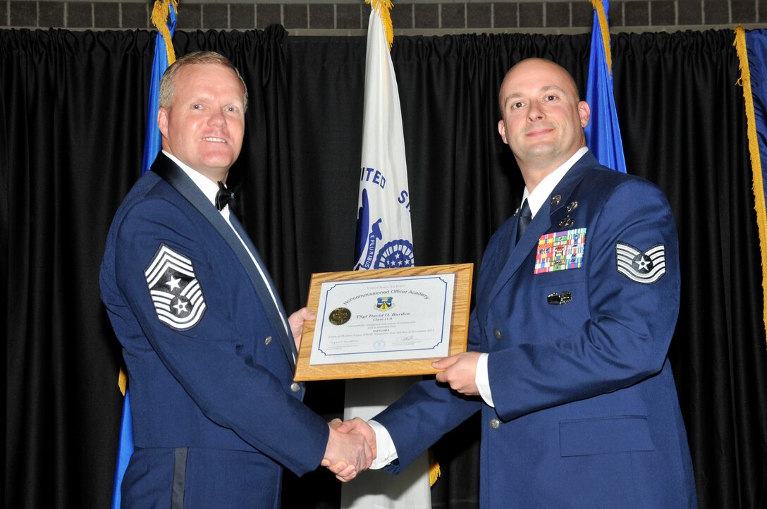 McGHEE TYSON AIR NATIONAL GUARD BASE, Tenn. -- Tech. Sgt. David O. Burden, right, receives the distinguished graduate award for NCO Academy Class 11-8 at The I.G. Brown Air National Guard Training and Education Center here from Command Chief Master Sgt. Kevin Candler, Nov. 3, 2011.  The distinguished graduate award is presented to students in the top ten percent of the class.  It is based on objective and performance evaluations, demonstrated leadership, and performance as a team player. (U.S. Air Force photo by Master Sgt. Kurt Skoglund/Released)