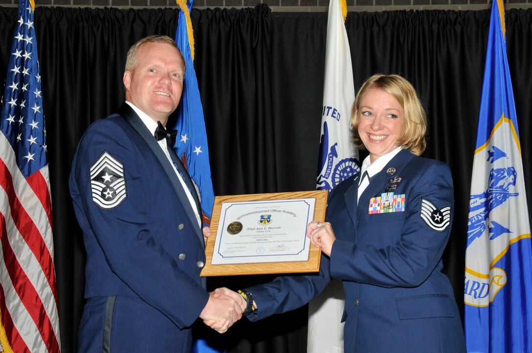 McGHEE TYSON AIR NATIONAL GUARD BASE, Tenn. -- Tech. Sgt. Ann L. Barrett, right, receives the distinguished graduate award for NCO Academy Class 11-8 at The I.G. Brown Air National Guard Training and Education Center here from Command Chief Master Sgt. Kevin Candler, Nov. 3, 2011.  The distinguished graduate award is presented to students in the top ten percent of the class.  It is based on objective and performance evaluations, demonstrated leadership, and performance as a team player. (U.S. Air Force photo by Master Sgt. Kurt Skoglund/Released)