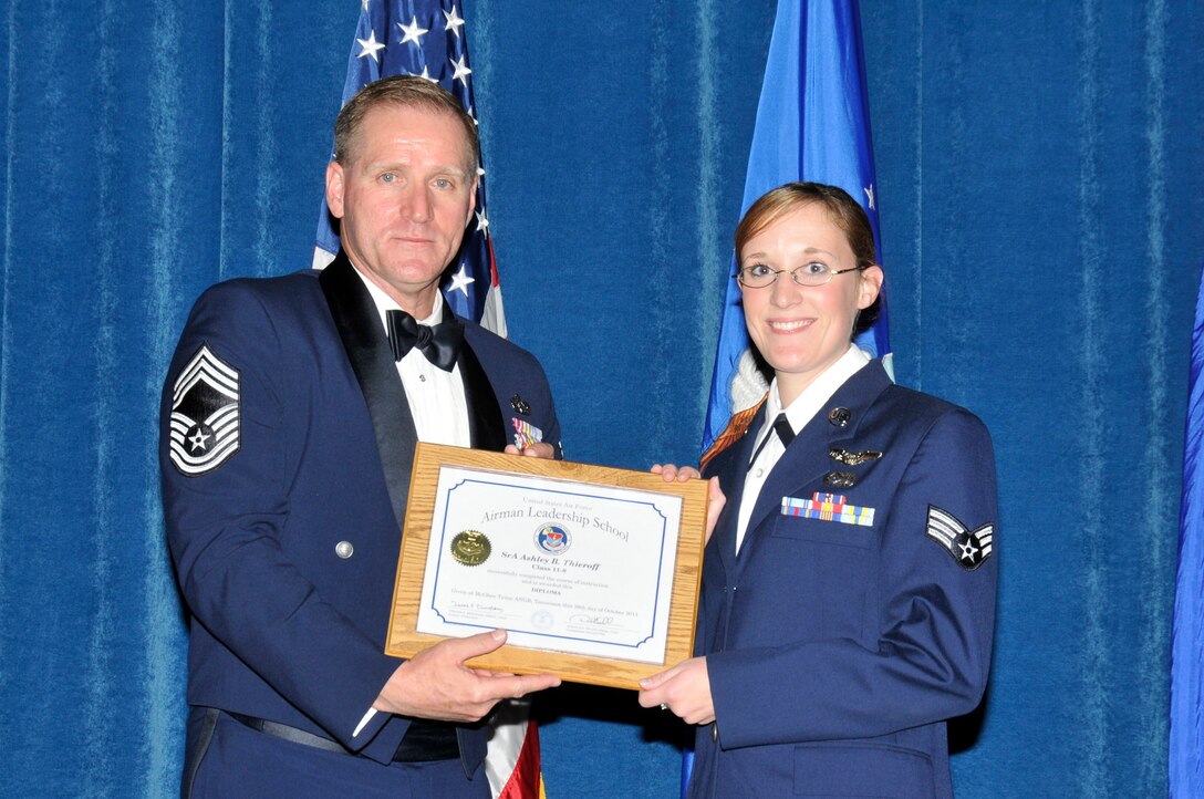 McGHEE TYSON AIR NATIONAL GUARD BASE, Tenn. -- Senior Airman Ashley Thieroff, right, receives the distinguished graduate award for Airman Leadership School Class 11-8 at The I.G. Brown Air National Guard Training and Education Center from Chief Master Sgt. Carl Collins, Oct. 28, 2011.  The distinguished graduate award is presented to students in the top ten percent of the class.  It is based on objective and performance evaluations, demonstrated leadership, and performance as a team player. (U.S. Air Force photo by Master Sgt. Kurt Skoglund/Released)