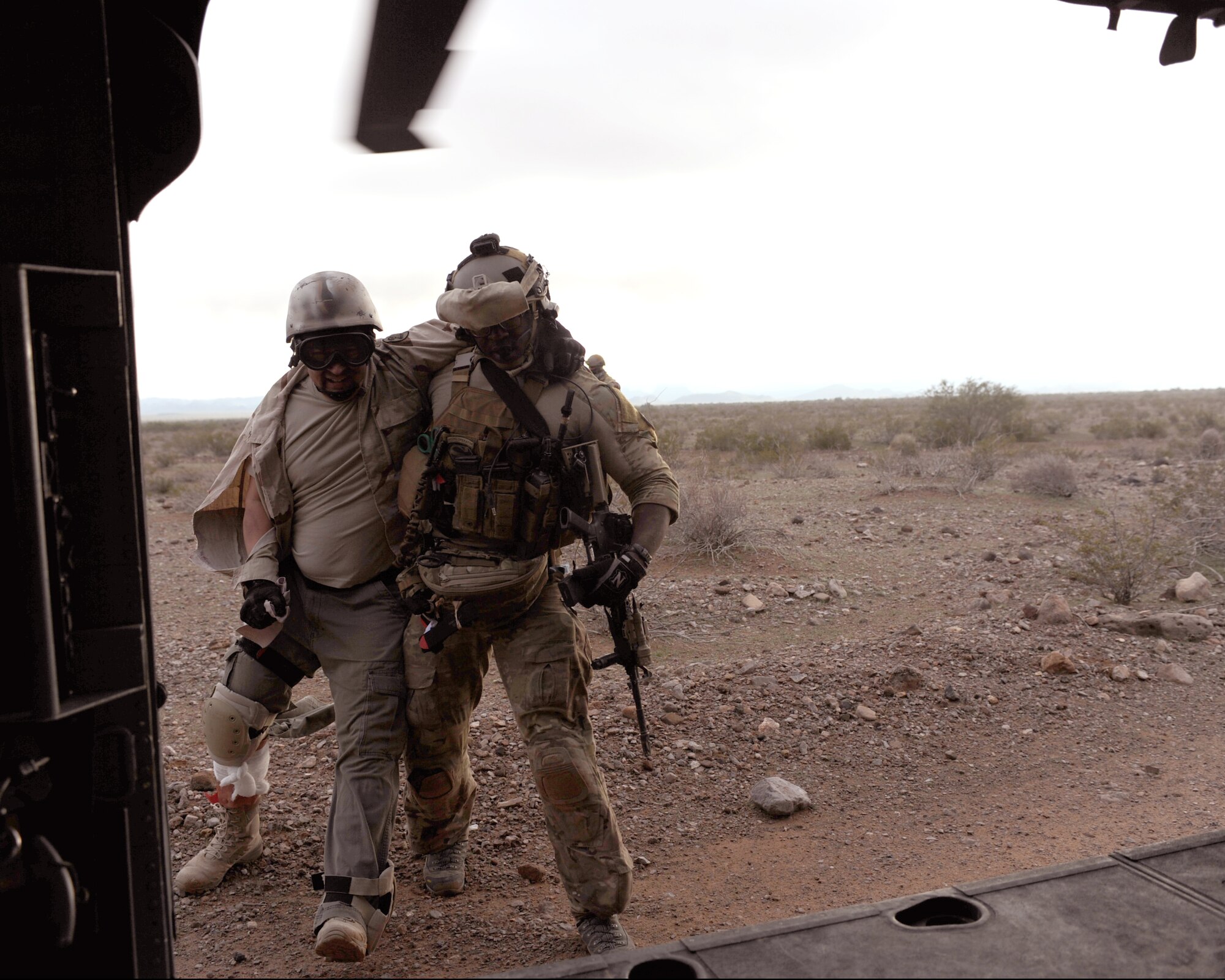 U.S. Air Force Staff Sgt. David Adams, 306th Rescue Squadron pararescueman, assists Master Sgt. Dominic Esparaza, 943rd Mission Support Flight, into an HH-60G Pave Hawk during the Operation Shocker exercise held at Gila Bend Auxiliary Field, Ariz., Dec. 14, 2011. The exercise tested the 943rd Rescue Group’s ability to respond to a variety of combat search and rescue scenarios prior to an upcoming deployment. (U.S. Air Force photo by Airman 1st Class Christine Griffiths/Released)