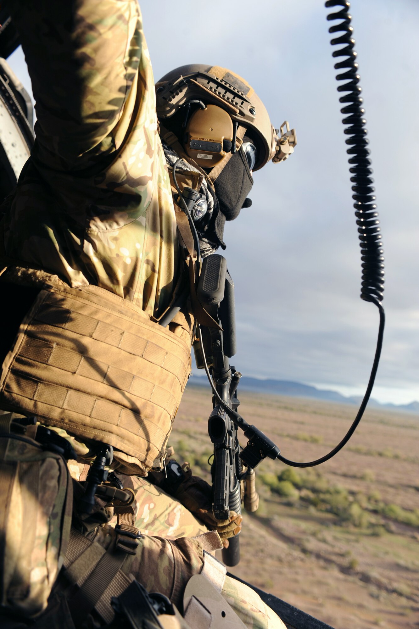 U.S. Air Force Senior Airman Jason Sweet, 306th Rescue Squadron pararescueman, scans the ground from the HH-60G Pave Hawk during the Operation Shocker exercise at Gila Bend Air Force Auxiliary Field, Ariz., Dec. 14, 2011. (U.S. Air Force photo by Airman 1st Class Christine Griffiths/Released)