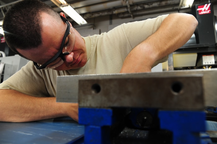 Master Sgt. George Greene adjusts a metal fixture at Joint Base Charleston - Air Base Dec. 15. The metals fixture will be used to hold aircraft parts. Greene is the aircraft metals technology section chief with the 437th Maintenance Squadron. (U.S. Air Force photo/Staff Sgt. Katie Gieratz) 
