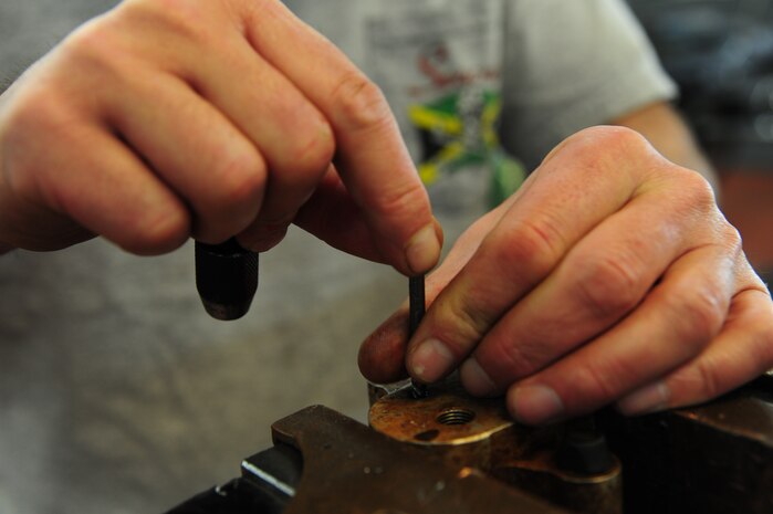 Ricky Childress removes a damaged bleeder valve from aircraft ground equipment at Joint Base Charleston - Air Base Dec. 15. The aircraft metals technology shop oversees more than 70 jobs monthly and provides services for other shops around base. Childress is a machinist with the 437th Maintenance Squadron. (U.S. Air Force photo/Staff Sgt. Katie Gieratz)
