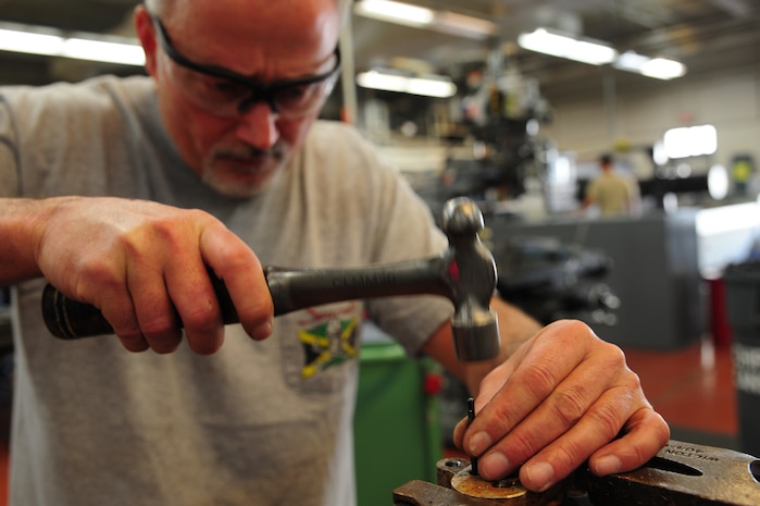 Ricky Childress removes a damaged bleeder valve from aircraft ground equipment at Joint Base Charleston - Air Base Dec. 15. The aircraft metals technology shop oversees more than 70 jobs monthly and provides services for other shops around the base. Childress is a machinist with the 437th Maintenance Squadron. (U.S. Air Force photo/Staff Sgt. Katie Gieratz)