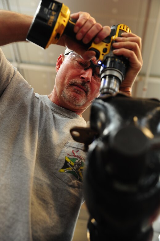 Ricky Childress removes a damaged bleeder valve from aircraft ground equipment at Joint Base Charleston - Air Base Dec. 15. The aircraft metals technology shop oversees more than 70 jobs monthly and provides services for other shops around the base. Childress is a machinist with the 437th Maintenance Squadron. (U.S. Air Force photo/Staff Sgt. Katie Gieratz)