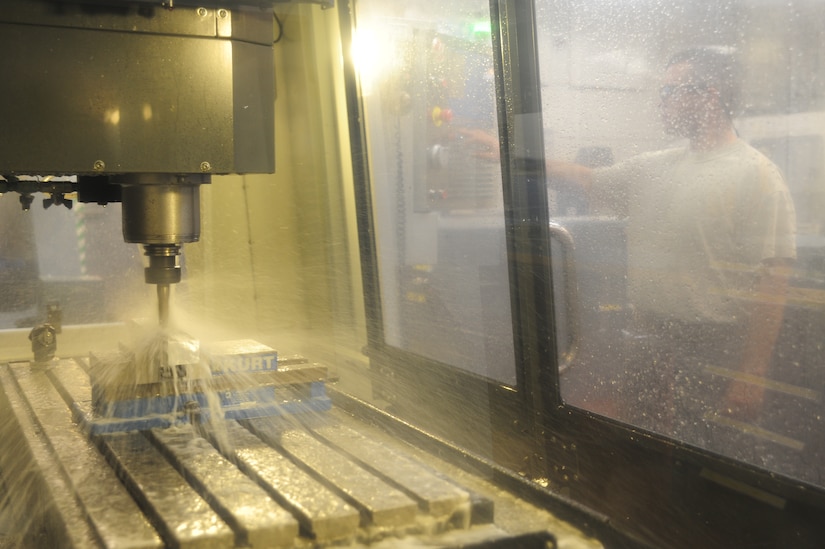 Master Sgt. George Greene inputs information into the Computer Numeric Control milling machine at Joint Base Charleston - Air Base Dec. 15. The CNC milling machine uses the data to create a fixture to hold aircraft parts. Greene is the aircraft metals technology section chief with the 437th Maintenance Squadron. (U.S. Air Force photo/Staff Sgt. Katie Gieratz) 
