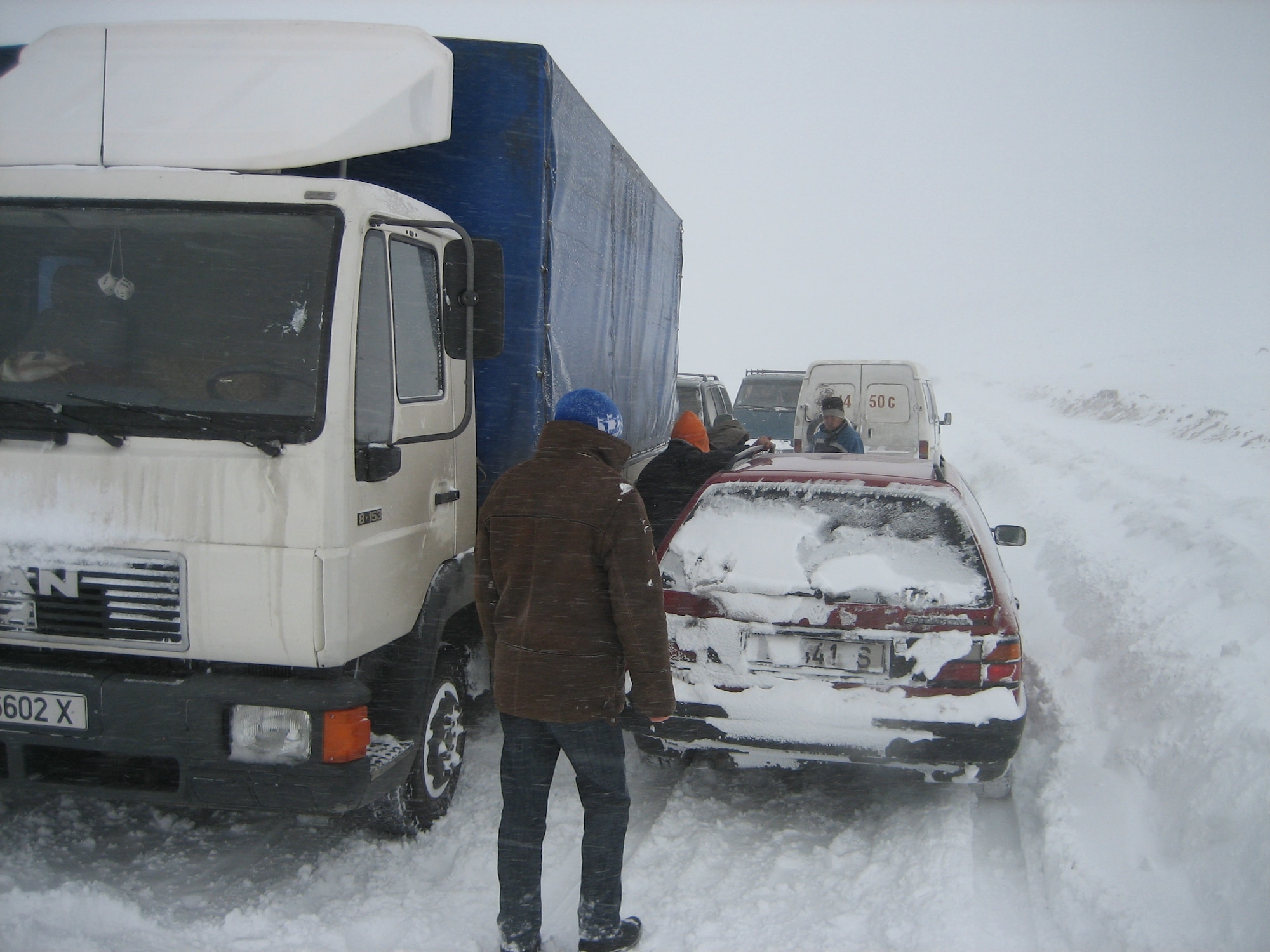 Volunteers with “Operation Warm and Dry” help a Kyrgyz stranded in a snow bank Dec. 29, 2011, while traveling to a distribution site in Kyrgyzstan. The Transit Center in Manas, the Kyrgyz Republic and the U.S. Embassy sponsor "Operation Warm and Dry". (U.S. Air Force Courtesy photo) 