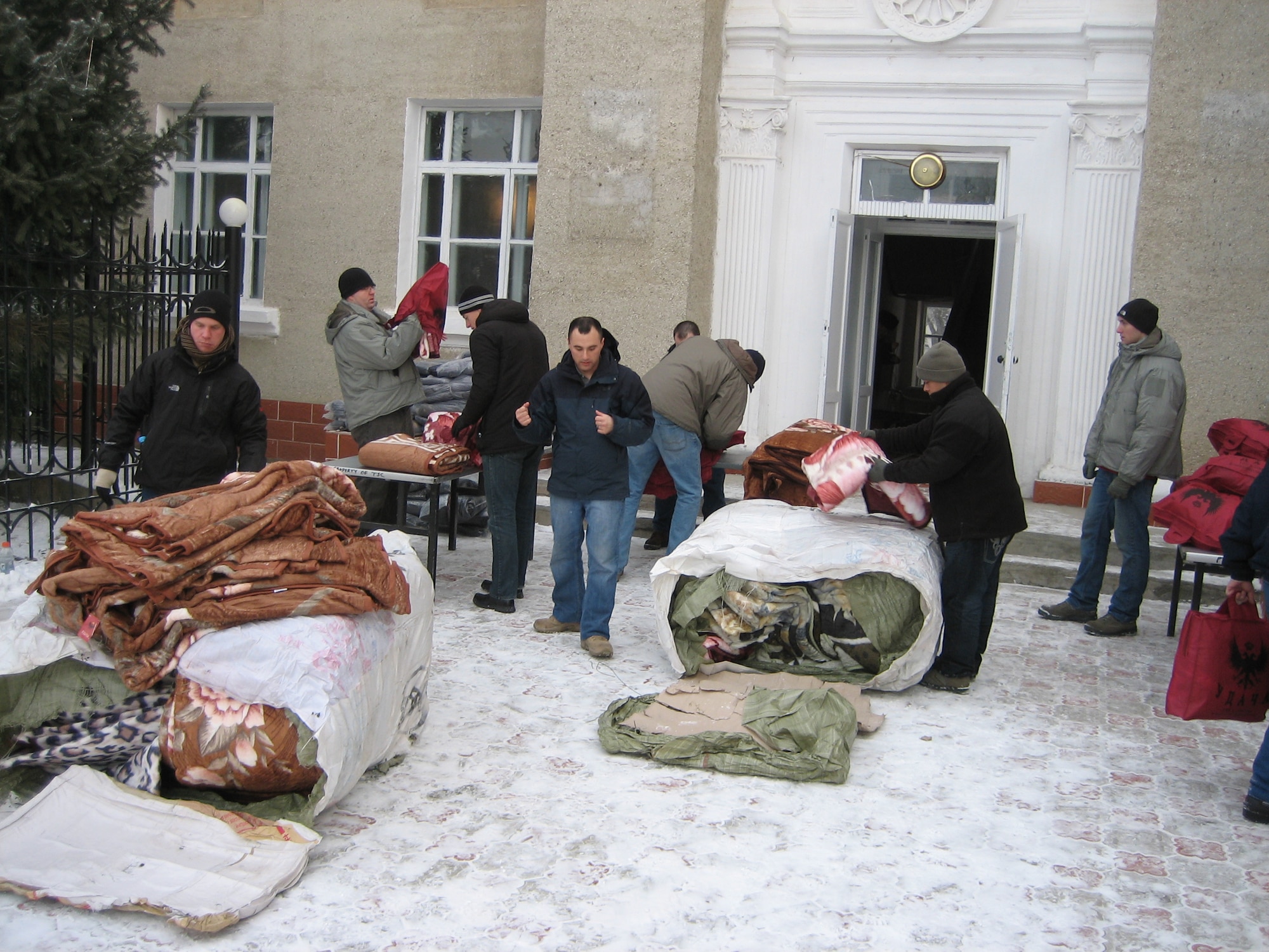 Volunteers unload blankets and jackets Dec. 27, 2011, at one of the five distribution sites during an “Operation Warm and Dry” trip in Kyrgyzstan. The Transit Center in Manas, the Kyrgyz Republic and the U.S. Embassy sponsor "Operation Warm and Dry". (U.S. Air Force Courtesy photo) 