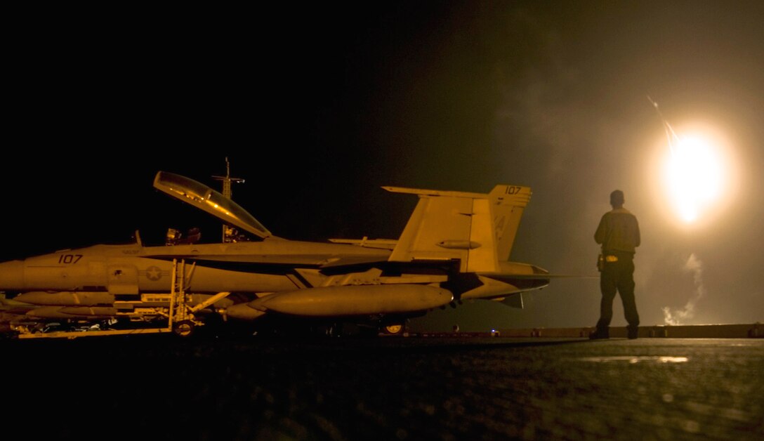A U.S. sailor observes celebratory flares marking the new year on the flight deck of the USS Carl Vinson under way in the Pacific Ocean, Jan. 1, 2012.