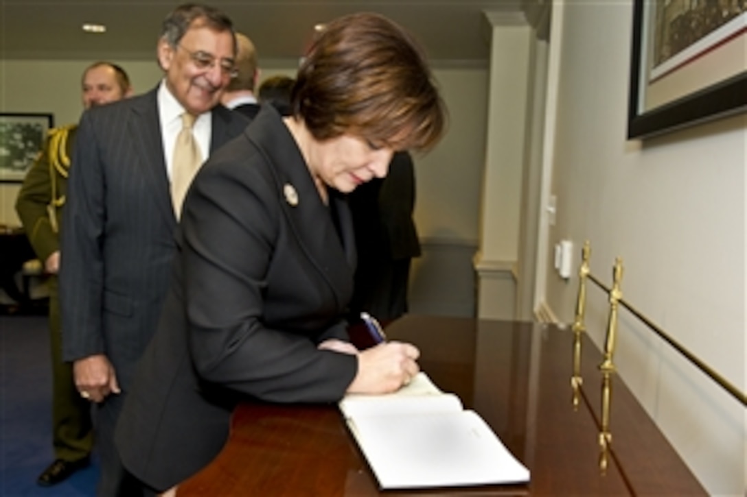 U.S. Defense Secretary Leon E. Panetta watches as Lithuanian Defense Minister Rasa Jukneviciene signs the guest book before a meeting at the Pentagon, Jan. 4, 2012. Panetta and Jukneviciene met to discuss bilateral defense issues and the continuing partnership between the United States and Lithuania.