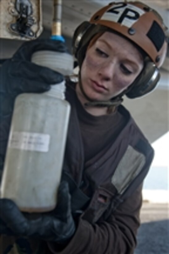 Airman Samantha Phillips collects fuel samples from an F/A-18E Super Hornet from Strike Fighter Squadron 14 on the flight deck of the aircraft carrier USS John C. Stennis (CVN 74) in the Arabian Sea on Jan. 3, 2012.  The John C. Stennis is deployed to the U.S. 5th Fleet area of responsibility conducting maritime security operations and support missions as part of Operation Enduring Freedom.  