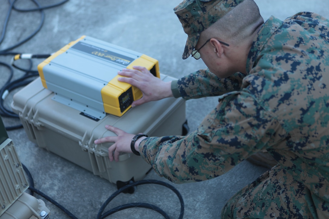 Lance Cpl. Joshua Chaffee, a field radio operator with Headquarters Company, 8th Marine Regiment, 2nd Marine Division, ensures a converter is correctly functioning which will allows the power held in several high energy lithium batteries can be turned into useable energy.