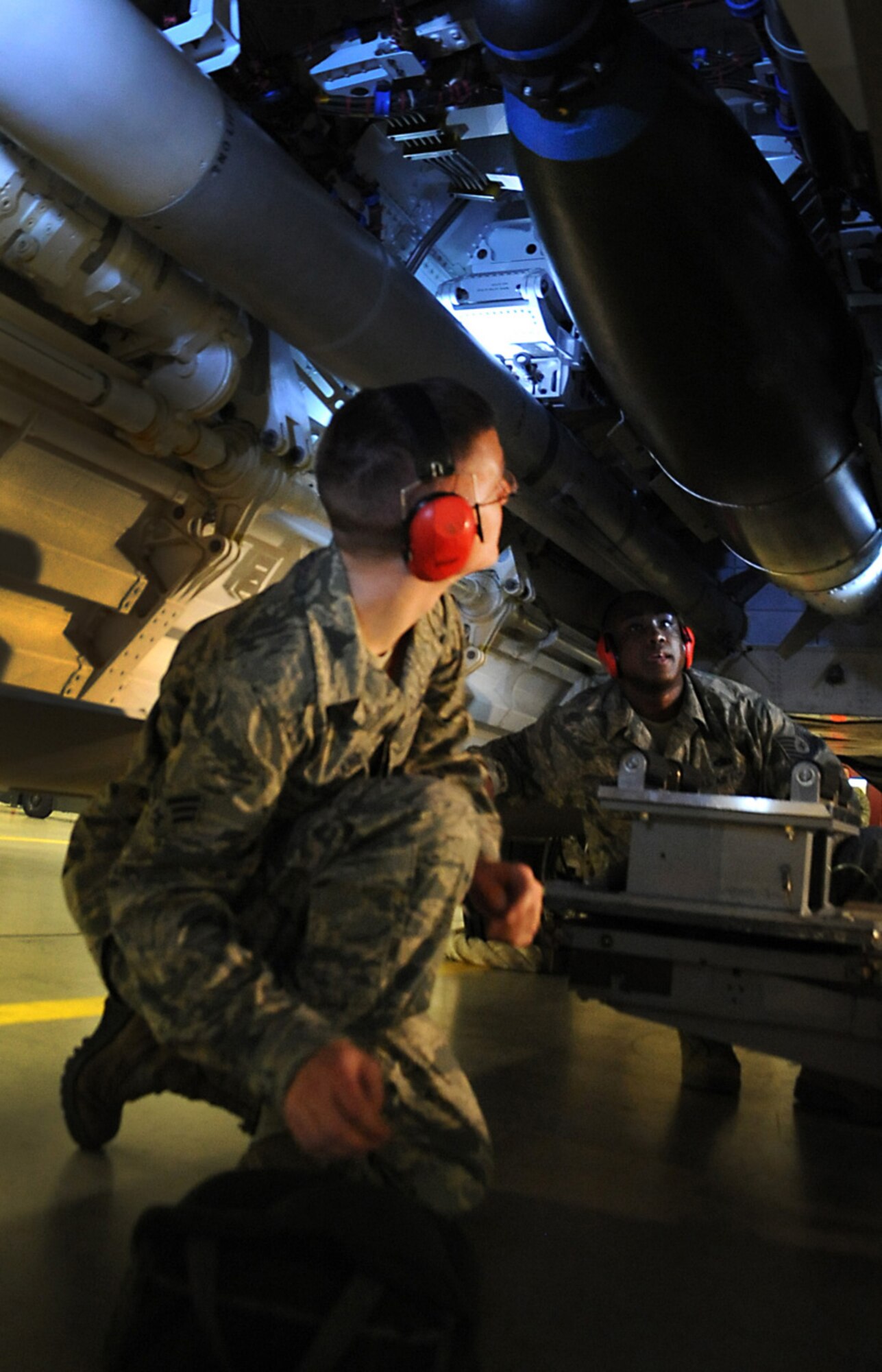 JOINT BASE ELMENDORF-RICHARDSON, Alaska -- Tech. Sgt. Kimmie Samuel, right, and Senior Airman Wesley Beversdorf keep their eyes locked on a joint direct attack munition after loading it during the weapons load crew of the year competition Dec. 14. Three teams competed for the annual award after winning a quarterly competition. Samuel and Beversdorf are both aircraft armament systems specialist with the 90th Aircraft Maintenance Unit. (U.S. Air Force photo/Staff Sgt. Cynthia Spalding) 
