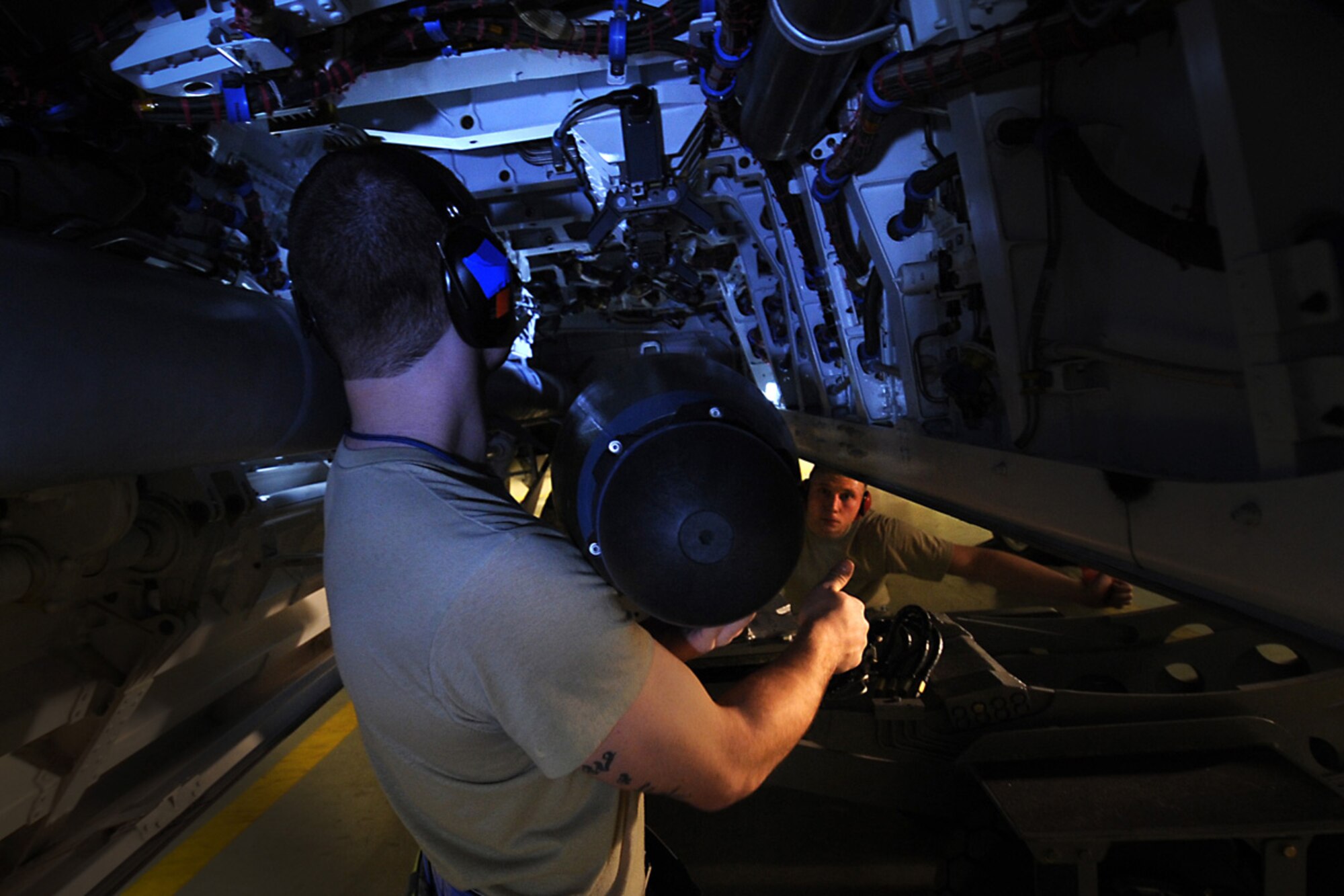 JOINT BASE ELMENDORF-RICHARDSON, Alaska --Airman 1st Class Craig Edwick signals to his team leader, Staff Sgt. Roger Roscoe to raise the ammunition during the weapons load crew of the year competition Dec. 14. Three teams competed for the annual award after winning a quarterly competition. Edwick and Roscoe are both aircraft armament systems specialist with the 525th Aircraft Maintenance Unit. (U.S. Air Force photo/Staff Sgt. Cynthia Spalding) 
