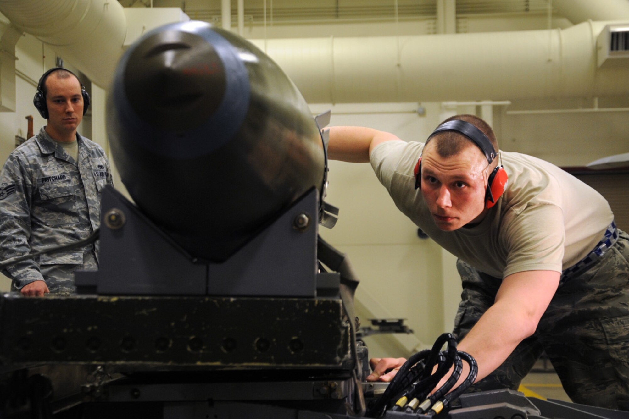 JOINT BASE ELMENDORF-RICHARDSON, Alaska --Senior Airman Alex Pritchard, left, inspects Staff Sgt. Roger Roscoe as he prepares a joint direct attack munition during the weapons load crew of the year competition Dec. 14. Three teams competed for the annual award after winning a quarterly competition. Pritchard is a weapons load evaluator with the 3rd Maintenance Operations Squadron and Roscoe is an aircraft armament systems specialist with the 525th Aircraft Maintenance Unit. (U.S. Air Force photo/Staff Sgt. Cynthia Spalding) 
