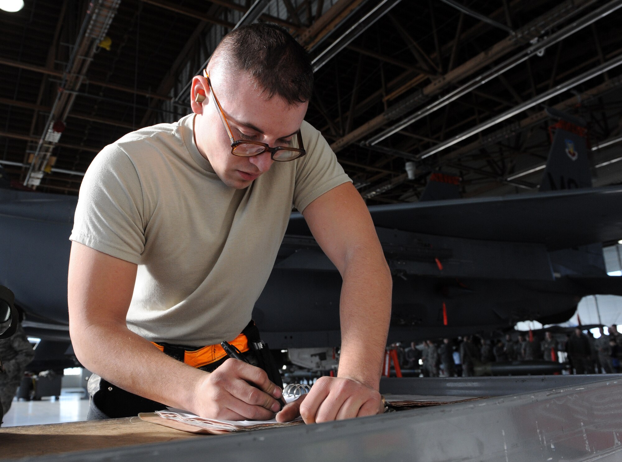 Airman 1st Class Steven Sloan, 391st Fighter Squadron weapons load crew three-man, fills out a technical order during a weapons load crew competition Jan. 4, 2012, at Mountain Home Air Force Base, Idaho. Gunfighters came to watch as the 389th, 391st and the Republic of Singapore Air Force 428th Fighter Squadrons compete head-to-head in the timed section of the competition. (U.S. Air Force photo by Senior Airman Debbie Lockhart)