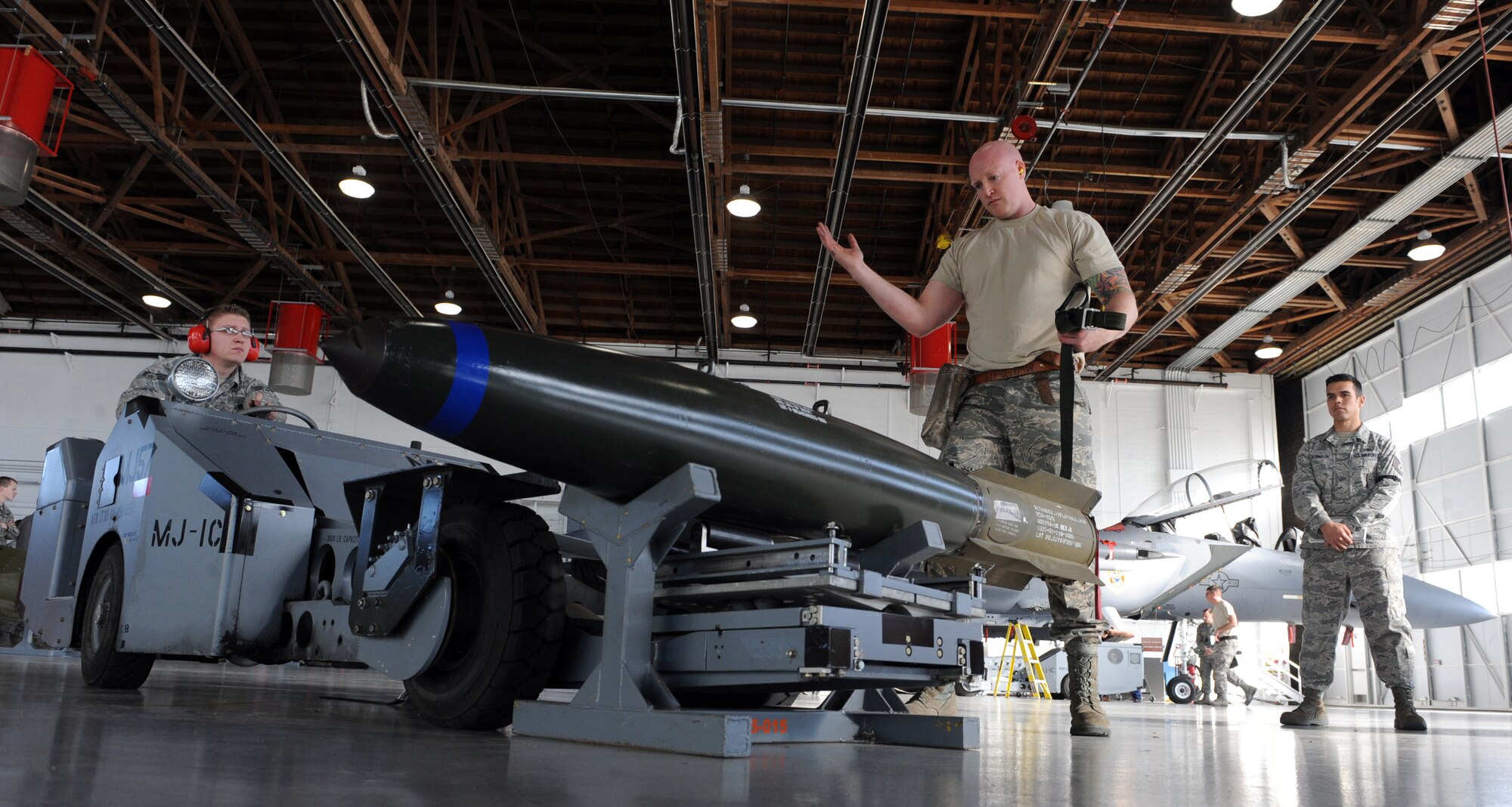 Staff Sgt. Chet Gregory, 389th Aircraft Maintenance Unit weapons load crew one-man, guides Senior Airman Lance Lund, 389th Aircraft Maintenance Unit weapons load crew three-man, as he picks up an MK-84 bomb during a weapons load crew competition Jan. 4,2012, at Mountain Home Air Force Base, Idaho. One team from each squadron was chosen to compete in this quarterly competition. This quarter the Republic of Singapore Air Force 428th FS took first place. (U.S. Air Force photo by Senior Airman Debbie Lockhart)