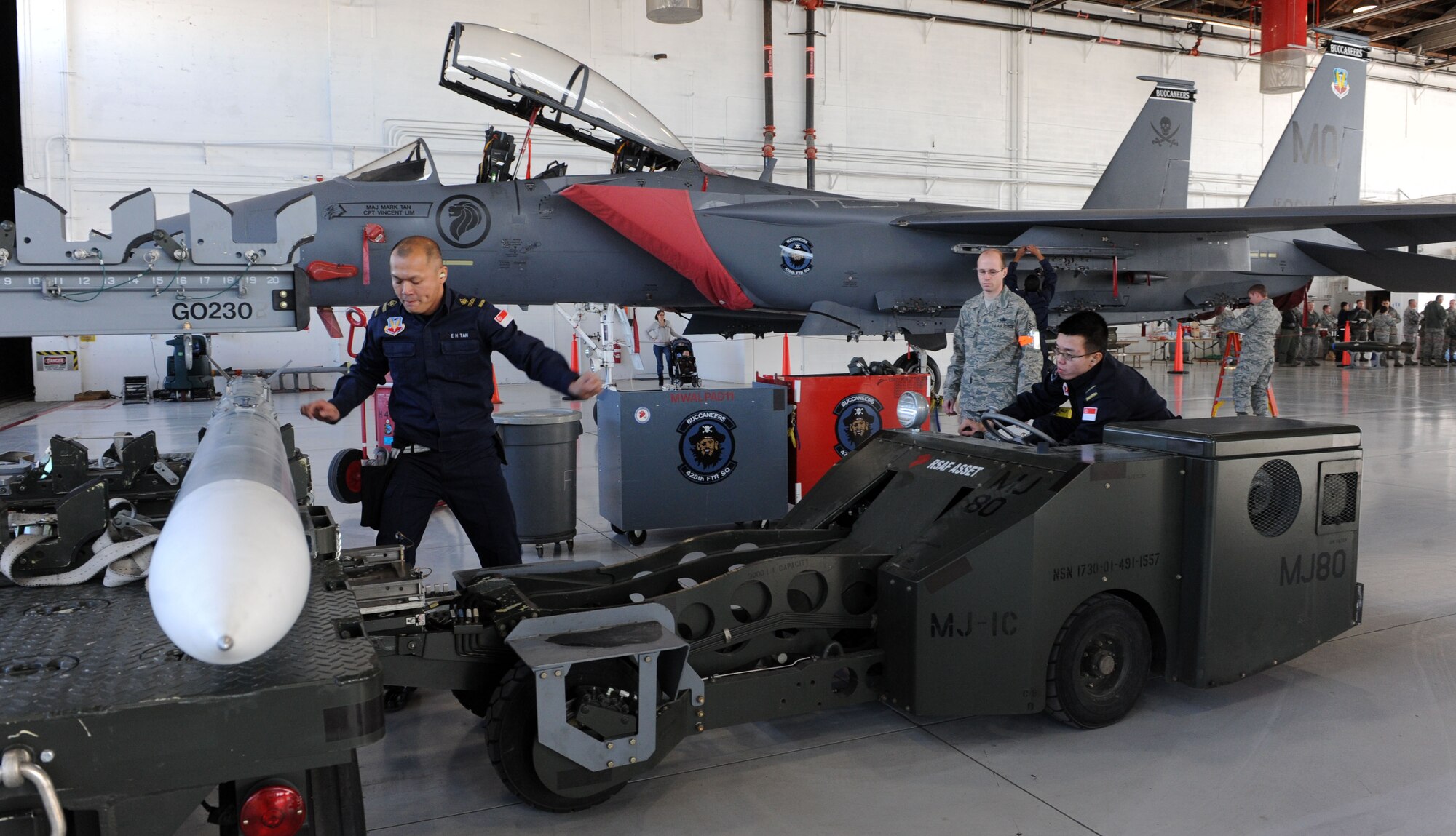 ME3 E.H. Tan guides ME1 Luo You Yang, both members of the Republic of Singapore Air Force 428th Fighter Squadron weapons load crew team, to safely pick up an inert missile during a weapons load crew competition Jan. 4, 2012, at Mountain Home Air Force Base, Idaho. The time allotted for loading during this competition is normally 50 minutes however, the teams were tasked to complete this load in under 15 minutes. The 428th FS took first place this quarter. (U.S. Air Force photo by Senior Airman Debbie Lockhart)