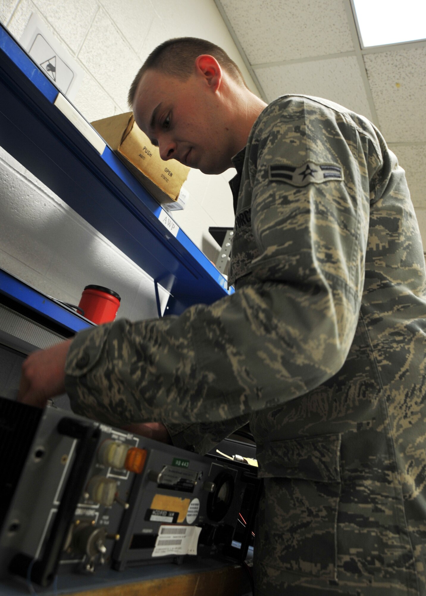 Airman 1st Class Nathan Pritchard, 22nd Communications Squadron airfield systems technician, adjusts an ultra high frequency transmitter Jan. 4, 2012, McConnell Air Force Base, Kan.  The Tucson, Ariz., native is responsible for maintaining McConnell’s meteorological, navigation and radio communication equipment used by air traffic controllers and aircraft.  (U.S. Air Force photo/Senior Airman Abigail Klein)