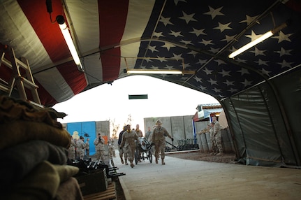 Airmen deployed to the 332nd Expeditionary Medical Group rush a wounded patient down Hero's Highway Jan. 22, 2007, at the Air Force theater hospital, Balad Air Base, Iraq. An American flag was mounted on the inner roof of the tent leading into the hospital so injured troops would be comforted knowing they were in an American area.  (U. S. Air Force photo/Airman 1st Class Nathan Doza)
