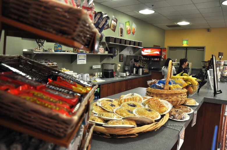 Snacks line the counter of the Coyote Cafe Jan. 5, 2012 while Ashley Murphy, and Ashlie Compton, both 9th Force Support Squadron baristas, prepare drinks for customers. Both Murphy and Compton said their goal is to have each customer leave with a smile and a little "pick me up" to get their day started. (Air Force photo by Senior Airman Chuck Broadway/Released)