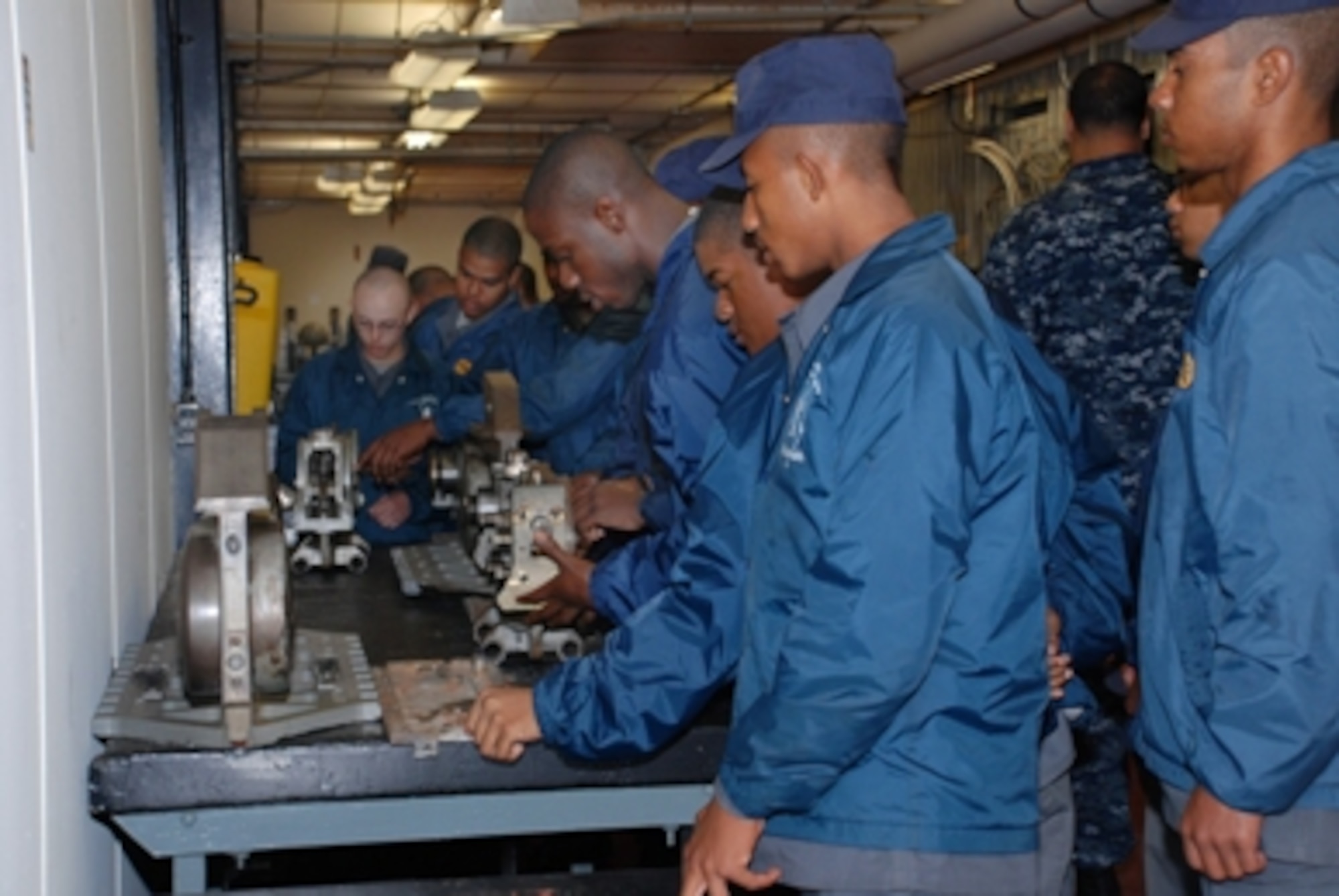 New Jersey Youth Challenge Academy Cadets visiting the Naval Air Warfare Center Aircraft Division’s manufacturing, prototyping and testing facilities, located on Joint Base McGuire-Dix-Lakehurst, examine aircraft carrier launch components machined to very fine tolerances prior to meeting those responsible for such precision work necessary for critical aircraft launch reliability. (U.S. Navy photo by Gaetan Mangano/Released)