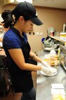Nia Carter, snack bar cook, plates a grilled cheese sandwich during the lunch rush on Seymour Johnson Air Force Base, N.C., Jan. 3, 2012. The snack bar is open for breakfast and lunch from 7:00 a.m. to 1:00 p.m. during the winter and 6:30 to 2:00 p.m. in the summer. Carter is from Lynnwood, Wash. (U.S. Air Force photo by Senior Airman Rae Perry)