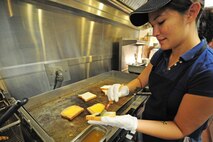 Nia Carter, snack bar cook, prepares grilled cheese sandwiches for lunch at the Three Eagles Golf Course on Seymour Johnson Air Force Base, N.C., Jan. 3, 2012. Different specials are offered throughout the week, including Italian Thursday, which offers homemade lasagna and spaghetti served on an all-you-can-eat buffet. Carter is a native of Lynnwood, Wash. (U.S. Air Force photo by Senior Airman Rae Perry)