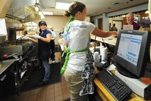 Rachel Pratt, snack bar cashier, hands a customer his change while Nia Carter and Jean Ballard prepare his order at the Three Eagles Golf Course snack bar on Seymour Johnson Air Force Base, N.C., Jan. 3, 2012. Pratt is a native of Chicago; Carter, cook, is from Lynnwood, Wash., and Ballard, head cook, hails from Seven Springs, N.C. (U.S. Air Force photo by Senior Airman Rae Perry)