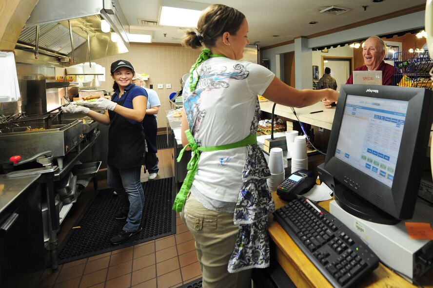 Rachel Pratt, snack bar cashier, hands a customer his change while Nia Carter and Jean Ballard prepare his order at the Three Eagles Golf Course snack bar on Seymour Johnson Air Force Base, N.C., Jan. 3, 2012. Pratt is a native of Chicago; Carter, cook, is from Lynnwood, Wash., and Ballard, head cook, hails from Seven Springs, N.C. (U.S. Air Force photo by Senior Airman Rae Perry)