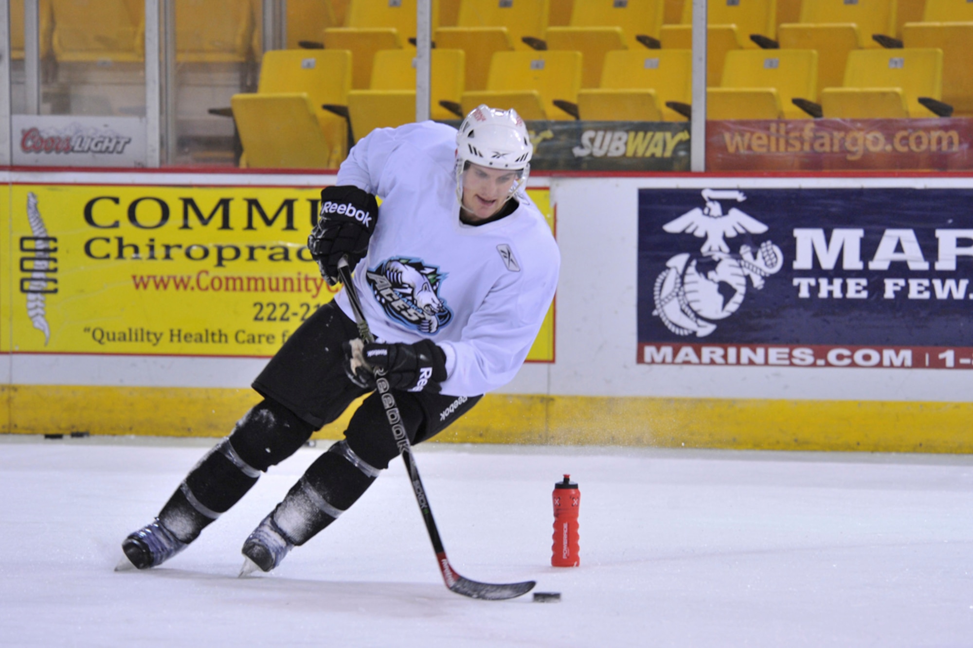 ANCHORAGE, Alaska  ?  Jacques Lamoureux, left wing for the Alaska Aces, maneuvers around a water bottle during a drill at practice at the Sullivan Arena Dec. 28. Lamoureaux not only plays professional hockey with the Aces, he?s also a second lieutenant assigned to the 673d Contracting Squadron at Joint Base Elmendorf-Richardson. (U.S. Air Force photo/Senior Airman Christopher Gross)