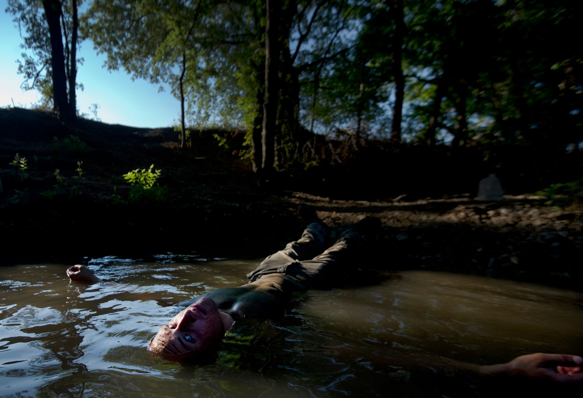 An Airman dips his body in water to clean off dirt and grass during Air Force Pararescuemen Indoctrination "Hell Week" Course on Sept. 6, 2011, at Lackland Air Force Base, Texas. During "Hell Week," Airmen simulate a real-world mission that could involve air, ground and water survival. Airmen must complete 62 weeks of training in addition to military basic training to become an Air Force pararescueman. (U.S. Air Force photo/Staff Sgt. Vernon Young Jr.)