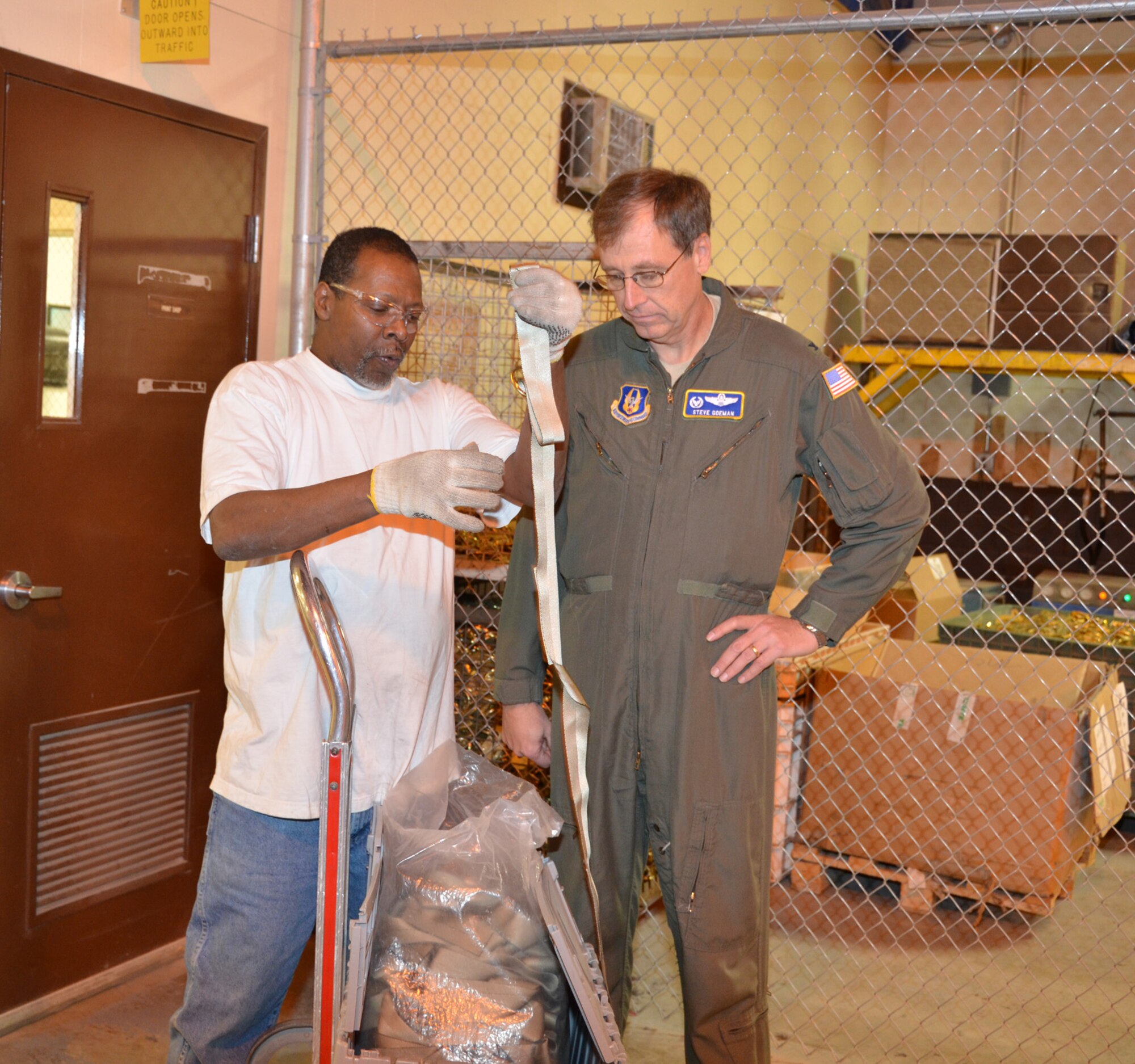 WRIGHT-PATTERSON AIR FORCE BASE, Ohio – Keith Lawson, TAC employee, shows Col. Stephen Goeman, 445th Airlift Wing commander, straps used to repair cargo nets during the wing’s visit to TAC Enterprises Dec. 19. (U.S. Air Force photo/Lt. Col. Cynthia Harris)