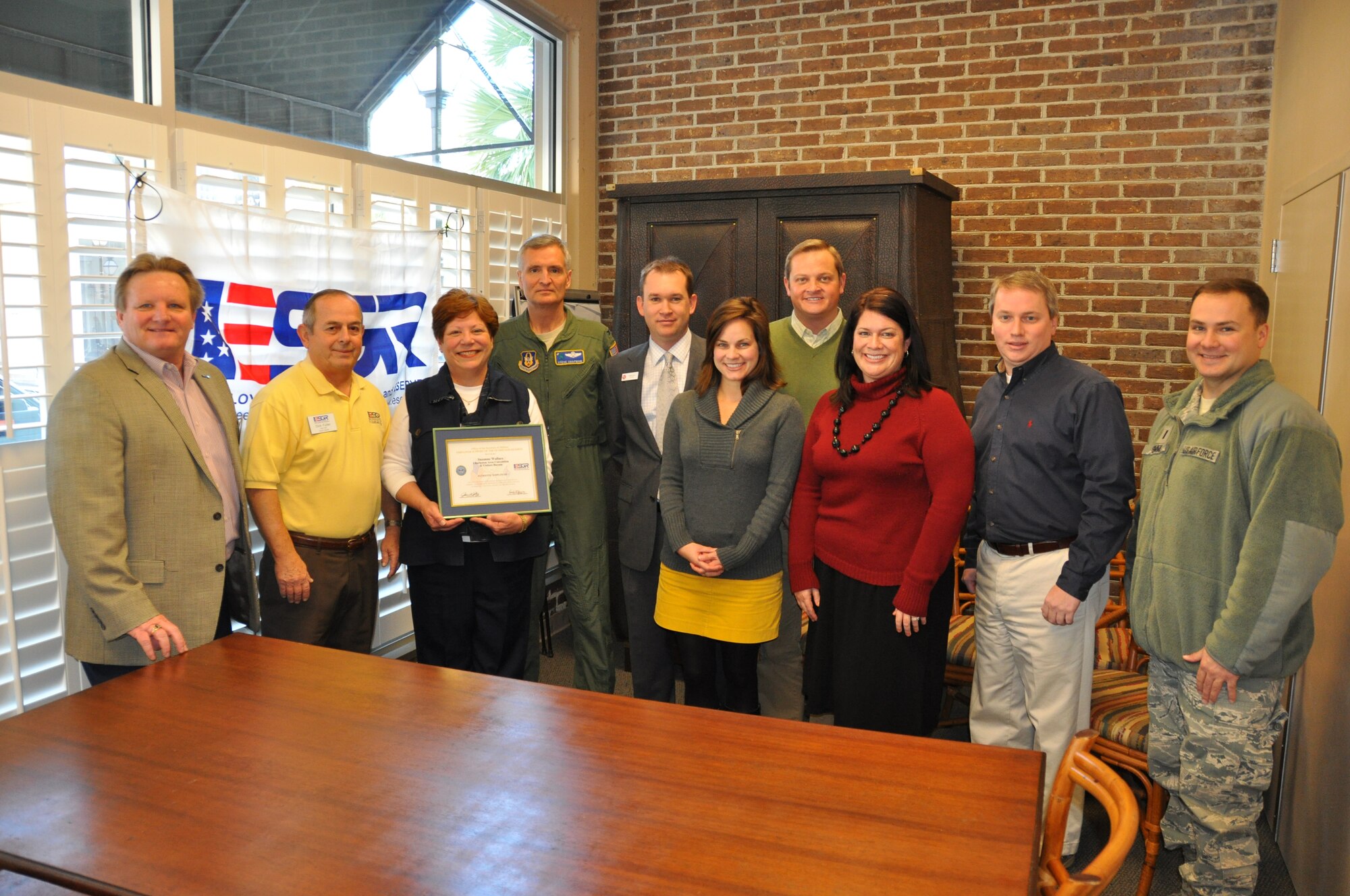 Col. Steven Chapman (center back), commander of the 315th Airlift Wing, presents Suzanne Wallace, director of the Charleston Area Convention and Visitors Bureau, with the Patriot Employer Award from the Employer Support of the Guard and Reserve.  She poses for the photo with members of the 315th Airlift Wing, ESGR committee members and members of the Charleston Area Convention and Visitors Bureau. (U.S. Air Force Photo/Capt. Wayne Capps)