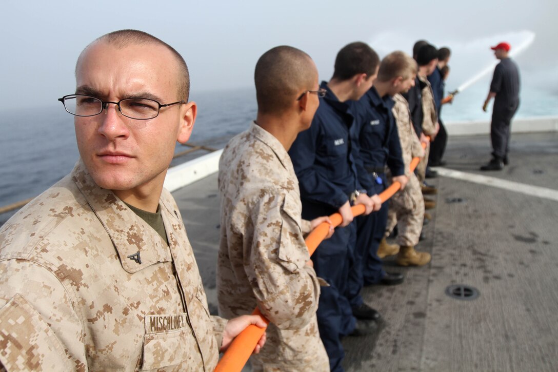 Machine-gunner Lance Cpl. Justin Mischloney mans a fire hose aboard the amphibious transport dock ship USS New Orleans (LPD 18) Jan. 5 during fire fighting training. Mischloney, a 23-year-old Alpena, Mich., native serves with Company L, Battalion Landing Team 3/1, the ground combat element for the 11th Marine Expeditionary Unit.  The 11th MEU is currently deployed as part of the Makin Island Amphibious Ready Group (MKIARG) as the U.S. Central Command theater reserve force, also providing support for maritime security operations and theater security cooperation efforts in the U.S. 5th Fleet area of responsibility.