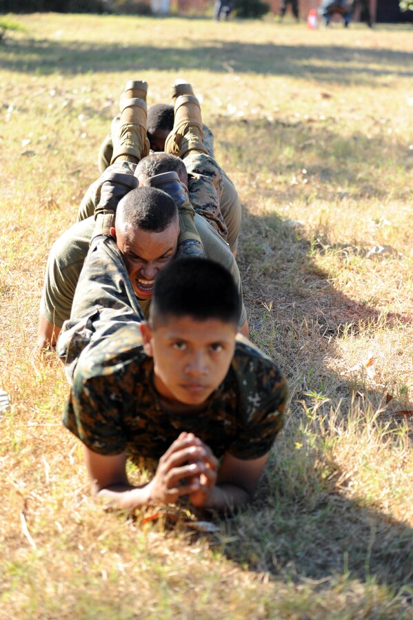 A Guatemalan paratrooper forms a line of squad planks with Sgt. Garival Perez, Sgt. Jhonny Agudelo and Lance Cpl. Ronald Russell, assigned to the Marine detachment aboard High Speed Vessel (HSV 2) Swift.  The exercise was part of a 10-day subject matter expert exchange between Guatemalan and U.S. service members during HSV-Southern Partnership Station 2012 (HSV-SPS 12).  HSV-SPS is an annual deployment to build partnerships in the Caribbean and Latin America.