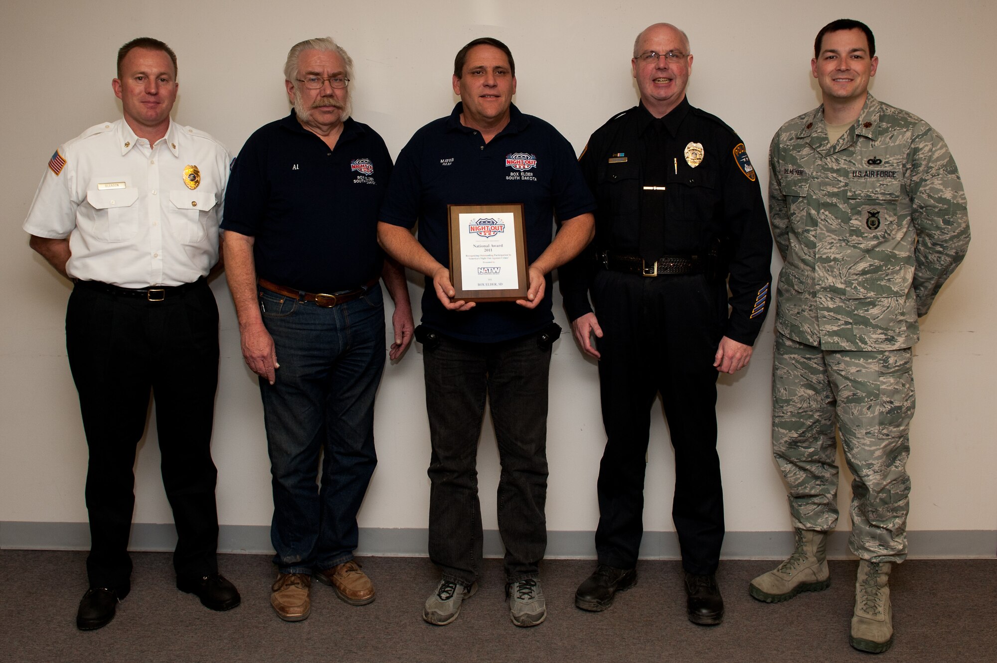 (From left to right) Christopher Gleason, Box Elder Fire Department chief; Al Todd, Box Elder Public Works director; Al Dial, mayor of Box Elder; Timothy Ryan, Box Elder Police Department chief and Maj. Steven Ohlmeyer, 28th Security Forces Squadron Commander, accept a National Night Out award at the City Hall in Box Elder, S.D., Jan. 5, 2012. Box Elder was the only city in South Dakota to receive the award, which is the result of the five organizations teaming up with the community and supporting the NNO mission of crime and drug prevention. (U.S. Air Force photo by Airman 1st Class Kate Thornton/Released) 