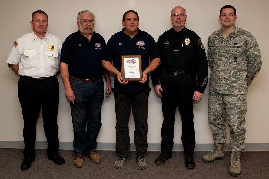 (From left to right) Christopher Gleason, Box Elder Fire Department chief; Al Todd, Box Elder Public Works director; Al Dial, mayor of Box Elder; Timothy Ryan, Box Elder Police Department chief and Maj. Steven Ohlmeyer, 28th Security Forces Squadron Commander, accept a National Night Out award at the City Hall in Box Elder, S.D., Jan. 5, 2012. Box Elder was the only city in South Dakota to receive the award, which is the result of the five organizations teaming up with the community and supporting the NNO mission of crime and drug prevention. (U.S. Air Force photo by Airman 1st Class Kate Thornton/Released) 