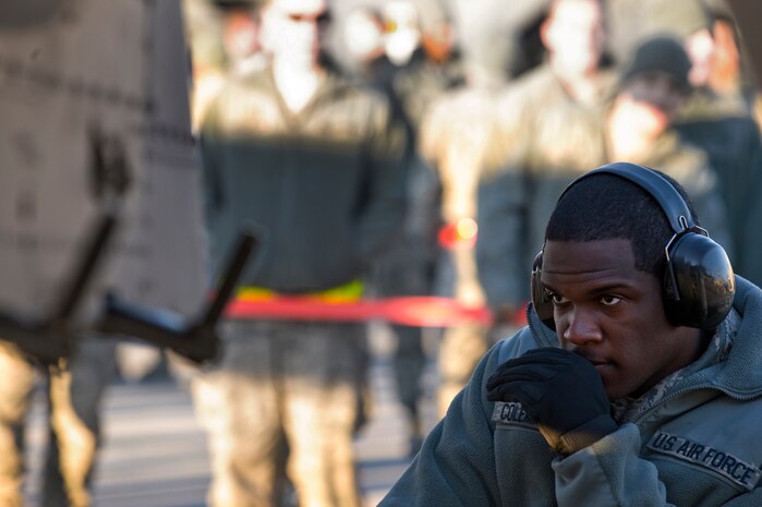 U.S. Air Force Senior Airman Jerell Coleman-McPhee, 757th Aircraft Maintenance Squadron aircraft armament systems journeyman, waits for a signal from his teammates to retrieve another bomb to load during the quarterly weapons load competition Jan. 6, 2012, at Nellis Air Force Base, Nev. Weapons load competitions are conducted quarterly to keep Airmen sharp and recognize superior performers. Weapons load teams are evaluated for use of the checklist, safety, and overall speed. (U.S. Air Force photo by Staff Sgt. William P.Coleman/Released)  